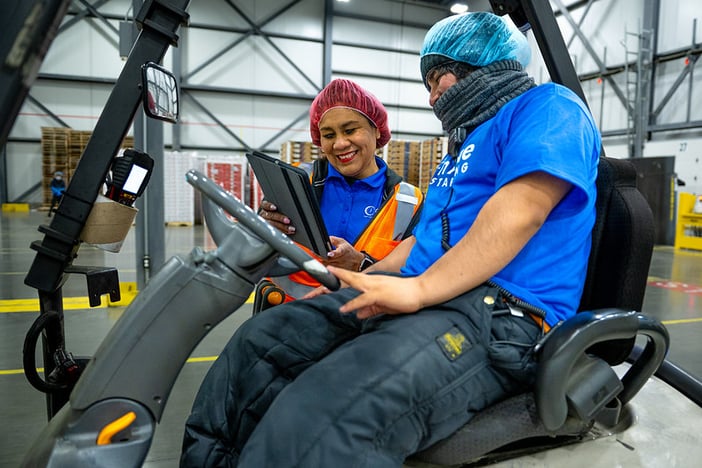 Woman holding a tablet while explaining warehouse safety policy